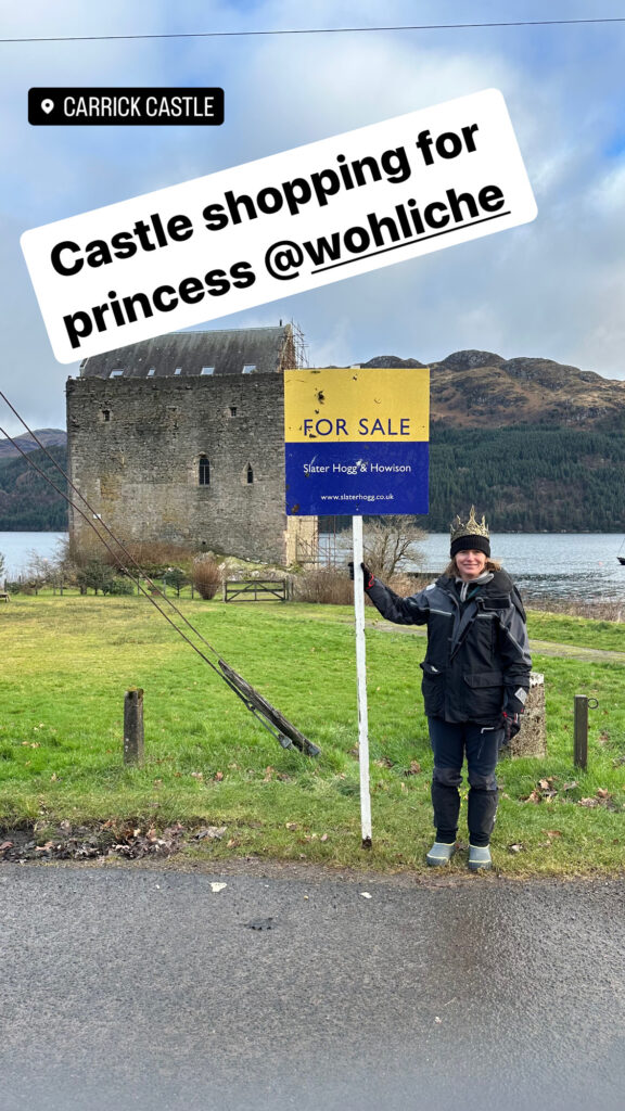 Sarah with for sale sign in front of castle